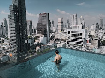 Man in Swimming Pool While Looking to Buildings