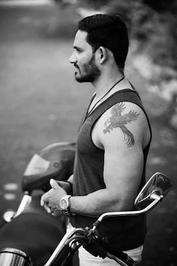 Man In Tank Top Beside A Motorbike