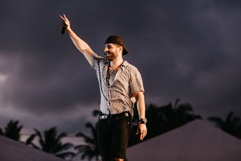 Man in White and Black Striped Shirt and Black Denim Jeans Standing on Gray Concrete Floor