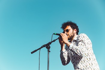 Man in White and Brown Long-sleeved Shirt Singing Holding Microphone