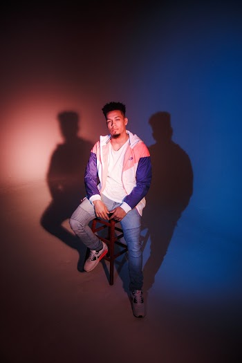 Man In White And Purple Jacket Sitting On Chair