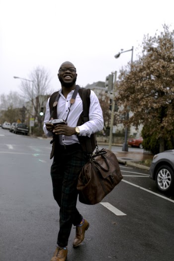 Man in White Button-up Dress Shirt Holding Camera While Smiling and Crossing Street