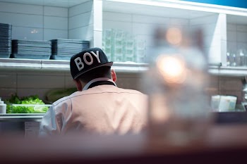 Man in White Button Up Shirt Wearing Boy Printed Black and White Fitted Hat