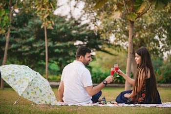 Man In White Collared Shirt Sitting On Ground With Woman In Blue Sleeveless Dress