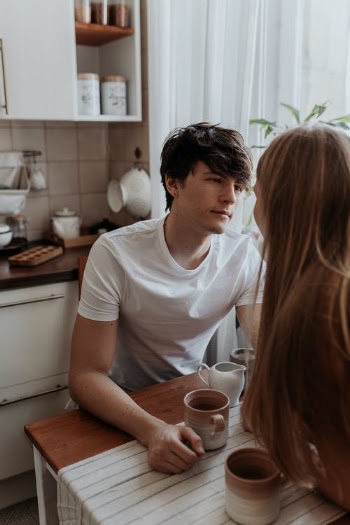 Man in White Crew Neck Shirt Sitting at a Wooden Table · Free Stock Photo