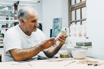 Man in White Crew-neck T-shirt Holding White Figurine