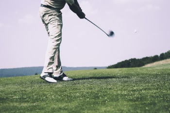 Man in White Denim Pants and Black Sandals Playing Golf during Daytime