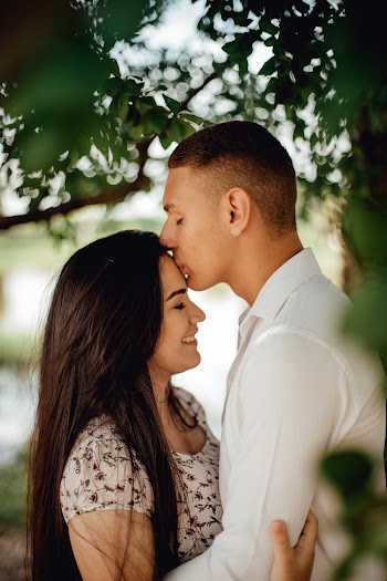 Man in White Dress Shirt Kissing Woman in Dress