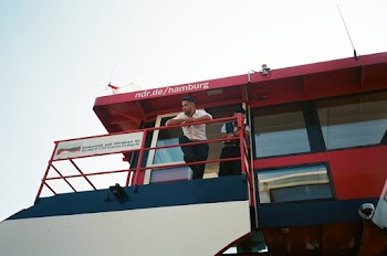 Man in White Dress Shirt Leaning on Metal Rails