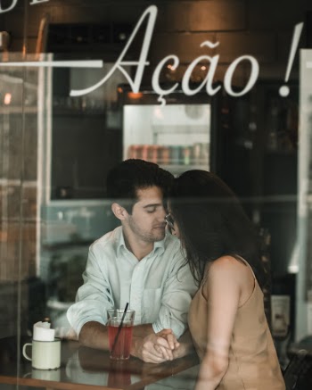 Man in White Dress Shirt Sitting Beside Woman in Brown Sleeveless Top