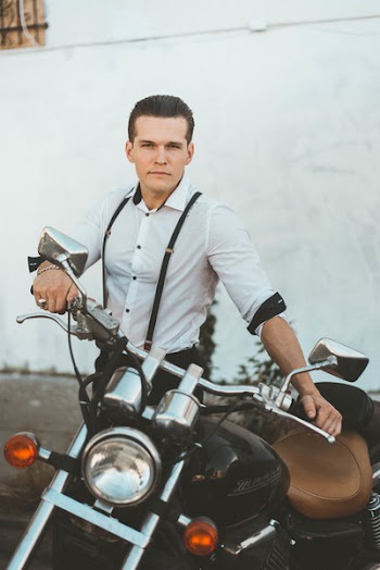 Man in White Dress Shirt Standing Beside Black Motorcycle