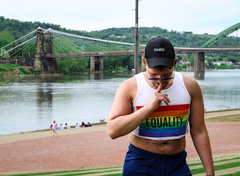 Man in White Equality Tank Top and Blue Shorts