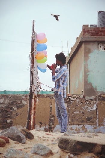 Man in White Gray and Teal Dress Shirt Standing in the Rock during Day Time