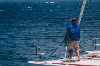 Man in White Hooded Jacket Riding on Boat