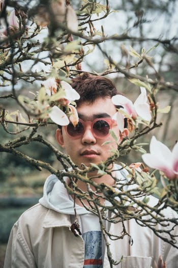 Man in White Hoodie Wearing Sunglasses Under White Cherry Blossom Tree · Free Stock Photo