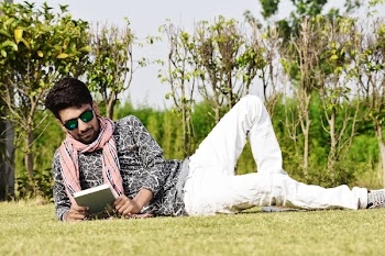 Man in White Pants Wearing Sunglasses Reading Book