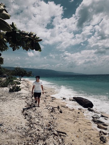 Man in White Shirt and Black Shorts Walking in Beach