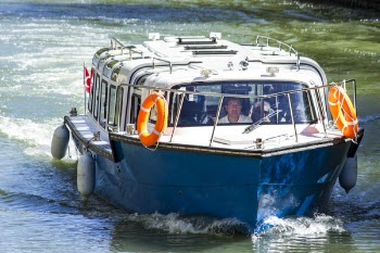 Man in White Shirt Driving Blue and White Boat