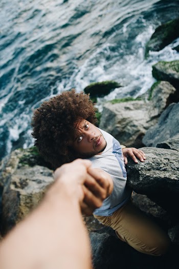 Man in White Shirt Holding Rock Formation
