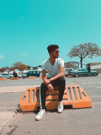 Man In White Shirt Sitting On Orange Concrete