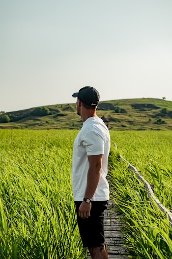Man in White Shirt Standing in Between Grasses