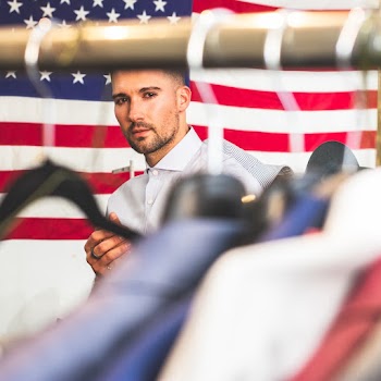 Man in White Shirt Standing in Front of U.S Flag
