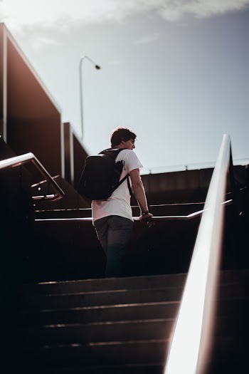 Man In White Shirt Standing on Stairs