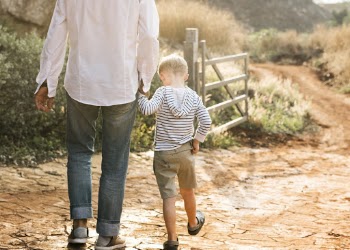Man In White Shirt Walking With Boy Near Wooden Fence Gate