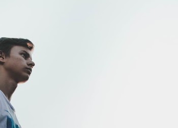 man in white suit looking at sky