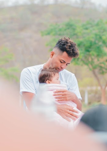 Man in White T-shirt Holding Baby With Towel