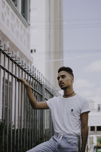 Man in White T-shirt Holding by the Railings
