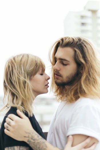 Man in White T-shirt Holding Woman in Black Top