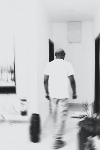 Man in White T-shirt Walking in Room