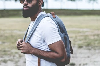 man in white tank top holding his bag