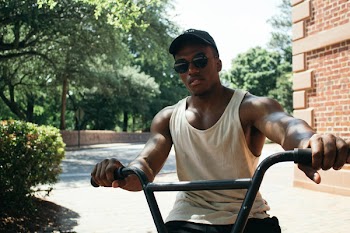 Man in White Tank Top Riding on Bicycle