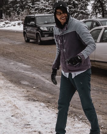 Man in Winter Jacket Laughing Near Cars