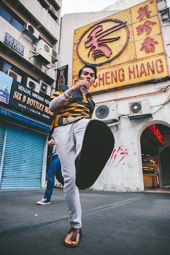 Man in Yellow and Black Shirt and White Pants