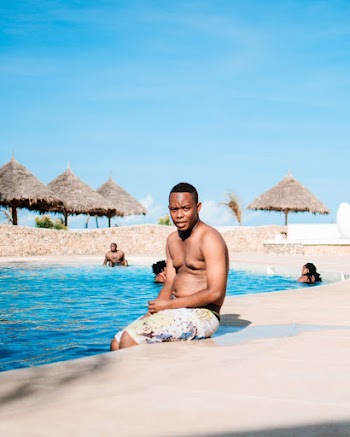 Man in Yellow and White Shorts by the Pool