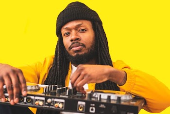 Man in Yellow Jacket Holding Dj Mixer Machine