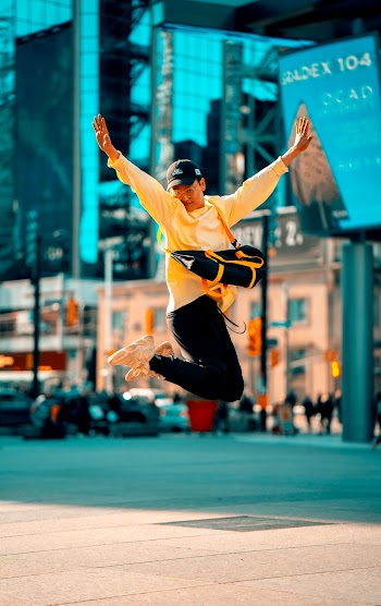 Man in Yellow Long-sleeved Shirt Jumping