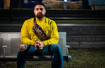Man in Yellow Long-sleeved Shirt Sitting on Gray Bench