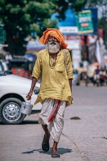 man in yellow top carrying gray container
