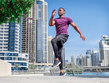 Man Jumping Above Gray Concrete Surface Under Blue Sky at Daytime