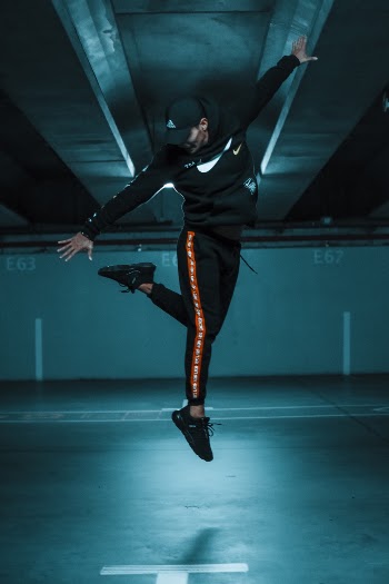 Man Jumping And Reaching His Left Leg In Mid Air