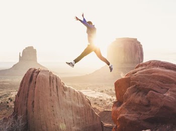 man jumping between two rocks