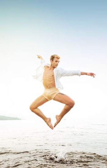 man jumping near seashore