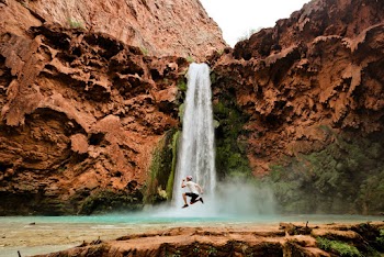 Man Jumping Near Waterfall