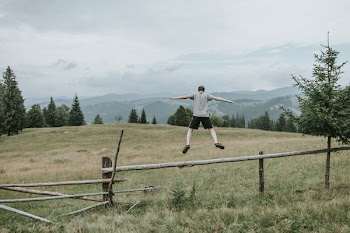 Man Jumping on Grass Field
