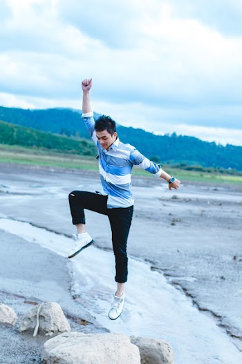 Man Jumping on Gray Rock Formation