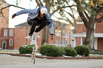 Man Jumps over Skateboard